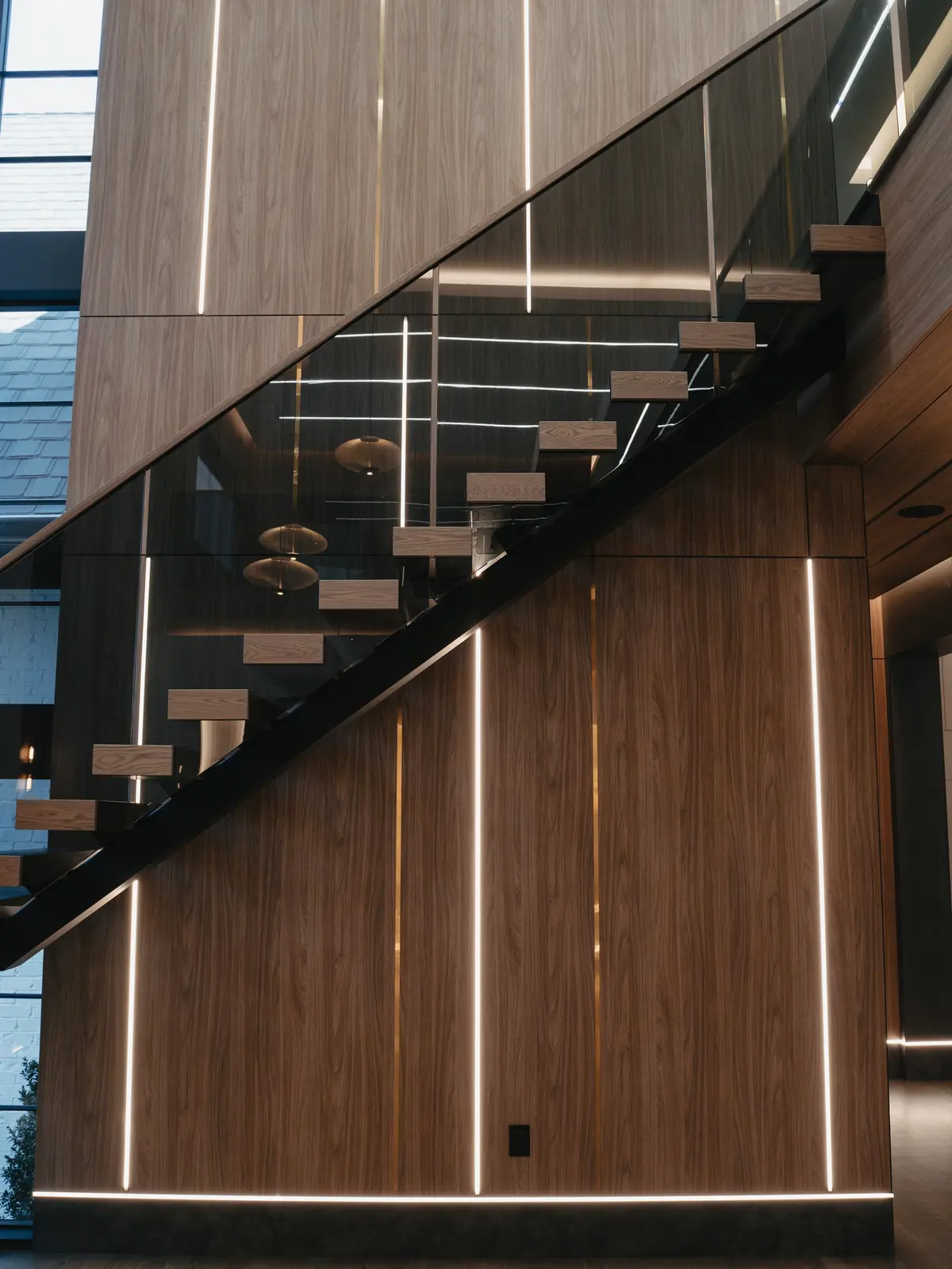 Modern staircase with wood treads, a glass rail and a vertical slat wall