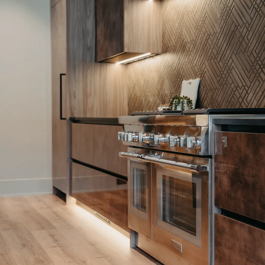 Modern custom home kitchen with walnut cabinetry and a professional range